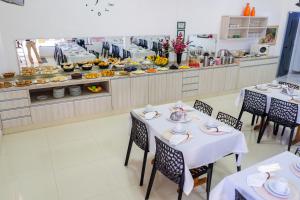a restaurant with two tables and a buffet of food at Pousada Paraiso in Guanambi