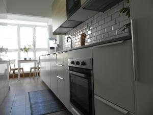 kuchnia z białymi szafkami i kuchenką w obiekcie Marea Urban w mieście La Laguna