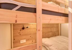 Etagenbett in einem Zimmer mit Holzwänden in der Unterkunft Detente au pied des pistes en famille in Génos