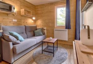 een woonkamer met een bank en een tafel bij A 4, découverte de la montagne - 80m des pistes in Génos