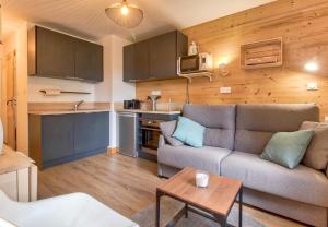 a living room with a couch and a small kitchen at A 4, découverte de la montagne - 80m des pistes in Val Louron