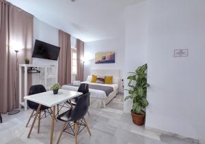 sala de estar con cama, mesa y sillas en ISA Cádiz, en Cádiz