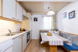 マイヤーホーフェンにあるAppartement Summerer Peterのキッチン(テーブル、フルーツボウル付)