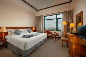 um quarto de hotel com uma cama grande e uma televisão em Nam Cuong Hai Duong Hotel em Hải Dương