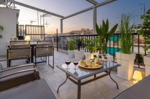 balcón con mesa y copas de vino en Acropolis Views Studio, en Atenas