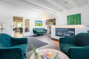 a living room with two green chairs and a table at Hotel Görtler in Seesen