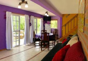 a living room with a table and a purple wall at CABAÑA LA MILAGROS REINA MORA in Merlo