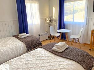 1 dormitorio con 2 camas, mesa y ventana en Novaqua Bed & Breakfast, en Olmué