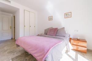 a bedroom with a bed with a pink blanket on it at MalagaSuite Torremolinos Lovely & Comfy in Torremolinos
