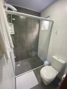 a bathroom with a shower and a white toilet at Vista da Serra. in Gramado