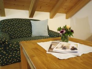 a coffee table with a couch and a vase of flowers at Ferienwohnung Boarbichlhof in Schenna