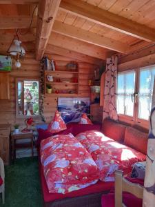 - une chambre avec un lit rouge dans une cabane en rondins dans l'établissement Ferienhaus "An der Seewiese", à Ostercappeln
