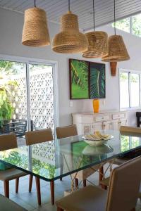 a dining room with a glass table and chairs at Casa para familia em Riviera, com WiFi in Bertioga