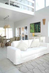 a white couch in a living room with a table at Casa para familia em Riviera, com WiFi in Bertioga