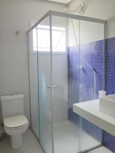 a bathroom with a shower and a toilet and a sink at Casa para familia em Riviera, com WiFi in Bertioga