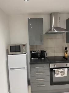 cocina con nevera blanca y microondas en Modern 1 Bedroom Holiday Apartment in Southminster en Southminster