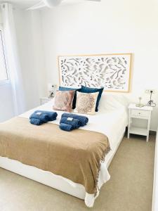 a bedroom with a large white bed with blue pillows at Seafront La Manga Apartment in La Manga del Mar Menor