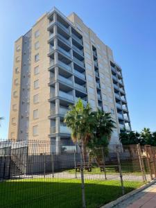 a tall building with a palm tree in front of it at Seafront La Manga Apartment in La Manga del Mar Menor