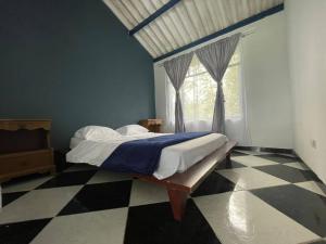 a bedroom with a bed and a checkered floor at Encantadora Finca privada con piscina, El Mirador in Fusagasuga