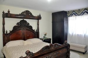 Un dormitorio con una gran cama de madera y una ventana en ANGEL'S SEA Pousada en Rio das Ostras