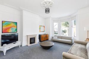 a living room with a couch and a tv at Lovely, modern & spacious 1-bed flat central Hove in Brighton & Hove