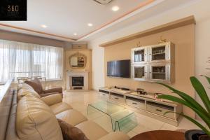 a living room with a couch and a tv at LUX VILLA with amazing BBQ, Pool Area & WIFI by 360 Estates in Is-Swieqi