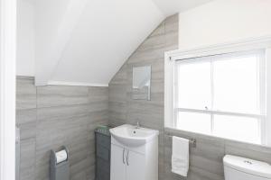 a bathroom with a sink and a toilet and a window at Lovely, modern & spacious 1-bed flat central Hove in Brighton & Hove
