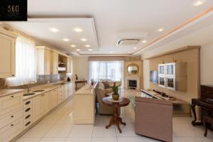 a large kitchen with white cabinets and a table at LUX VILLA with amazing BBQ, Pool Area & WIFI by 360 Estates in Is-Swieqi