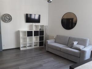 uma sala de estar com um sofá e um espelho em CURIAL INSOLITE em Chambéry