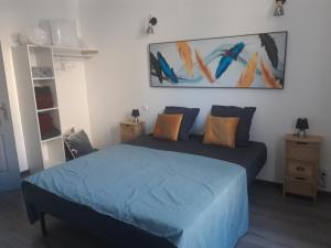 a bedroom with a blue bed and a painting on the wall at CURIAL INSOLITE in Chambéry