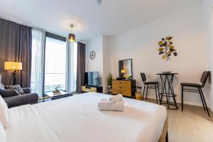 a bedroom with a large white bed and a living room at Liv Residence in Dubai