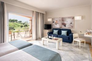pokój hotelowy z łóżkiem i kanapą w obiekcie La Cala Resort w mieście La Cala de Mijas