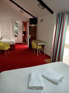 a hotel room with a bed and a desk and a bedroom at Hotel Saint Amant in Le Palais +6 photos
