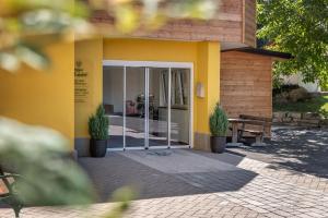 un bâtiment jaune avec une porte et un banc dans l'établissement Landgasthof Allerberger, à Wals