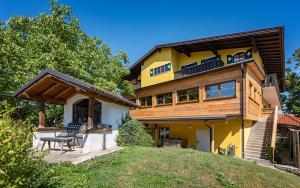 ein gelbes Haus mit einer Terrasse in der Unterkunft Landgasthof Allerberger in Wals