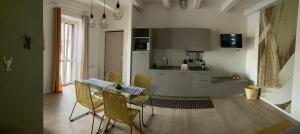 a kitchen with a table and chairs in a room at Appartamenti il borgo girasole in Busca