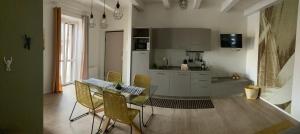 cocina con mesa y sillas en una habitación en Appartamenti il borgo girasole, en Busca