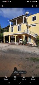 a large yellow house with a car parked in front of it at DINO 1 in Trou aux Biches