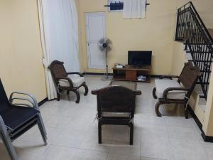 a living room with chairs and a table and a television at DINO 1 in Trou aux Biches