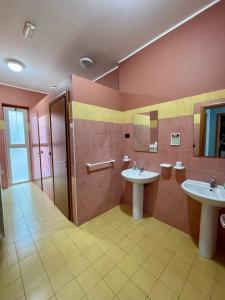 a bathroom with two sinks and a shower at Ostello Fiume Tirino in Bussi sul Tirino +8 photos