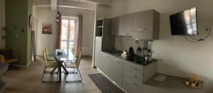 cocina con mesa, nevera, mesa y sillas en Appartamenti il borgo girasole, en Busca