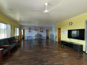 a living room with a couch and a flat screen tv at THE CLOUD KINABALU- HOUSE in Ranau