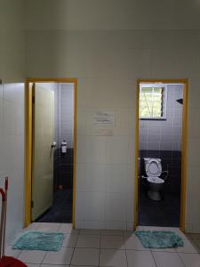 a bathroom with a toilet and a door with a window at THE CLOUD KINABALU- HOUSE in Ranau