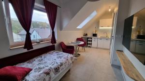 a bedroom with a bed and a table and a kitchen at Apartament Strumyk in Czarnków