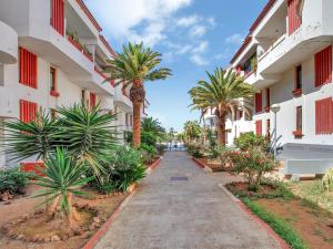 a street in front of a building with palm trees at LAS AMERICAS BEACH, 2 Bedrooms, Fiber, Pool in Playa de las Americas