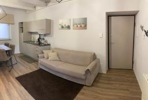 a living room with a couch and a kitchen at appartamenti Il Borgo orchidea in Busca