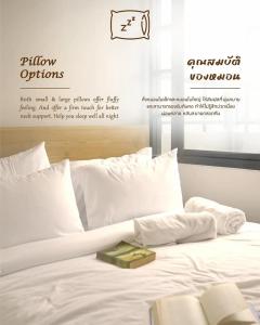 a white bed with a book on top of it at YAKTHAI POSHTEL in Bangkok