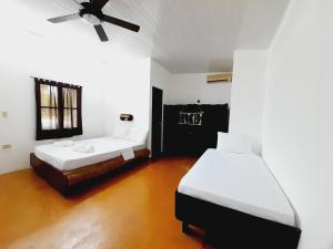 a room with two beds and a ceiling fan at Hibiscus Garden in Santa Catalina