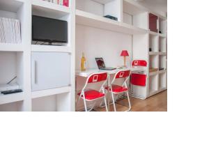 a kitchen with a table and two chairs and a refrigerator at La petite maison parisienne in Levallois-Perret