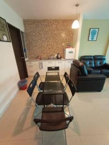 uma sala de estar com uma mesa e cadeiras e um sofá em InstaStay 2-Unit Marina Island Teluk Batik View Lagoon - 1 Bedroom Queen Bed & 2 Single Bed em Lumut